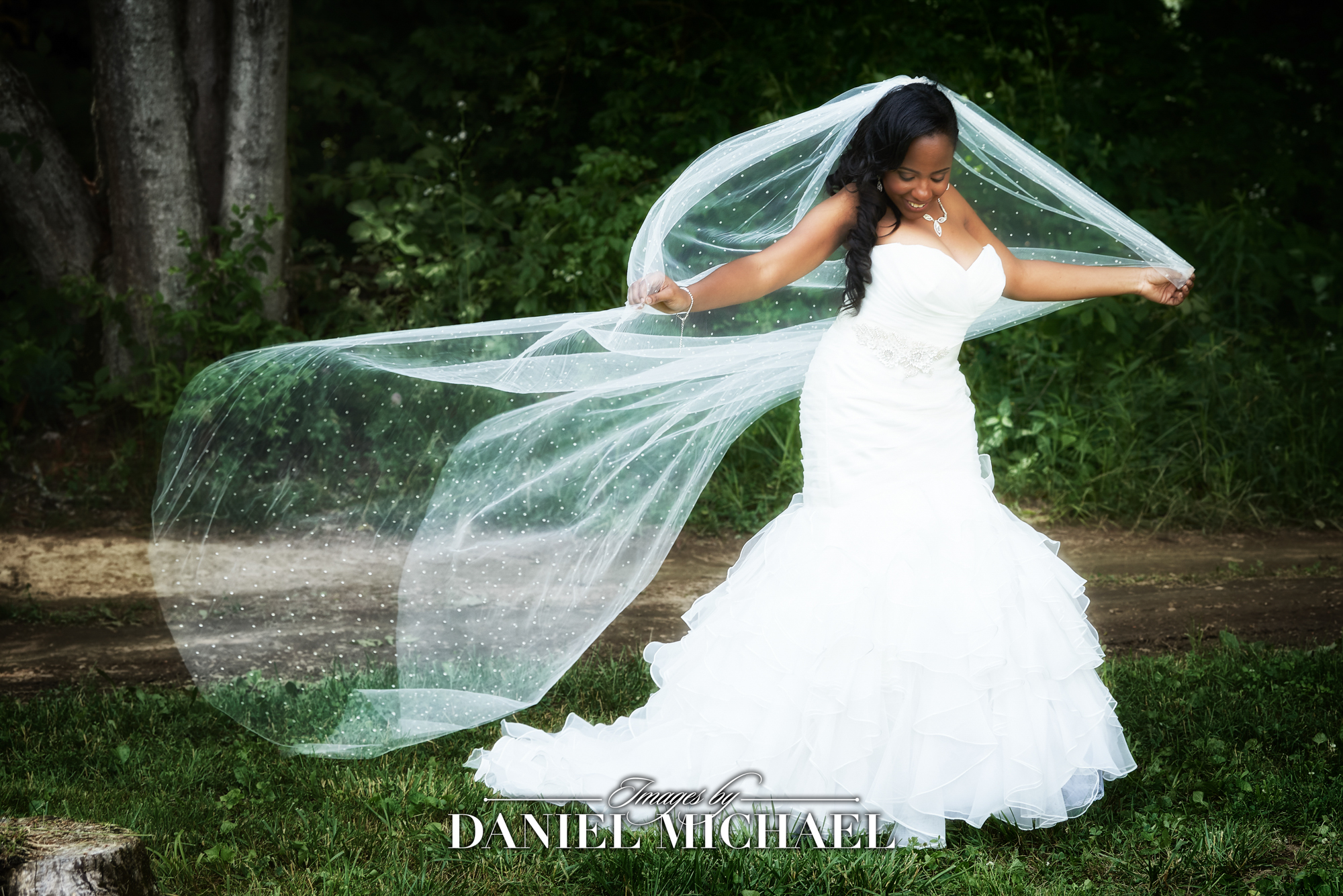Black bride in stunning wedding dress with flowing veil captured by the best wedding photographer in Cincinnati